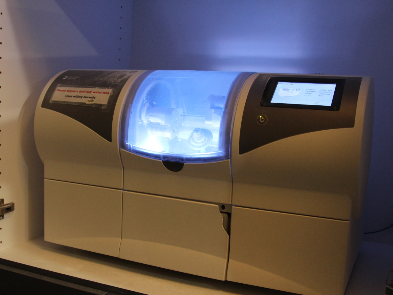 Dental milling machine creating a custom dental restoration